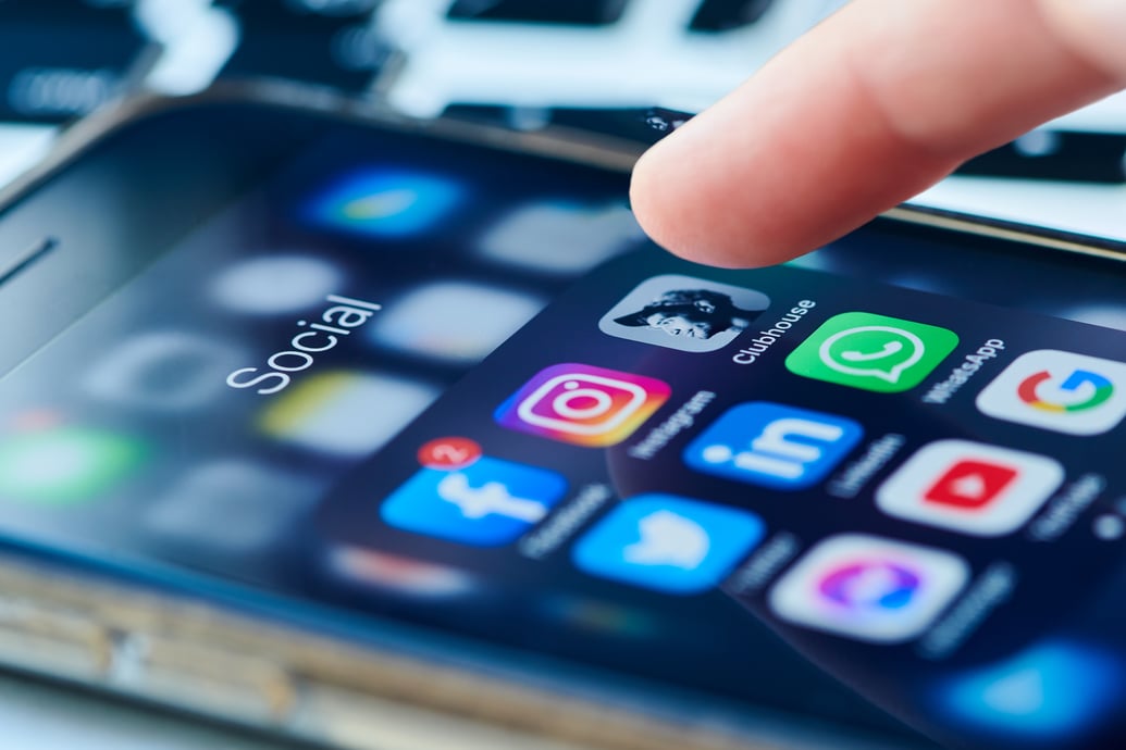 Person with finger on social media icon.