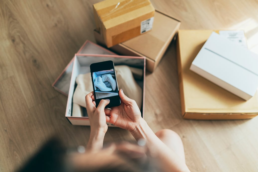 Woman taking a picture of her online order to represent eCommerce return fraud - Shift4Shop